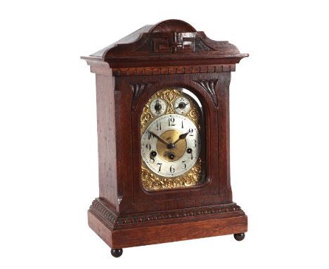 A Junghams oak cased mantle clock, the silvered dial with Arabic numerals, 30cms wide.