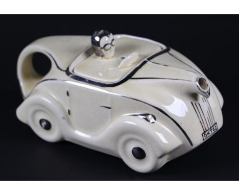 An Art Deco novelty teapot in the form of a car, registration no. 820236, 22cms long.Condition ReportOKT42, crazing to the gl