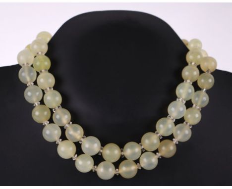 A double strand of pale green / yellow jade bead necklace with rock crystal spacers.