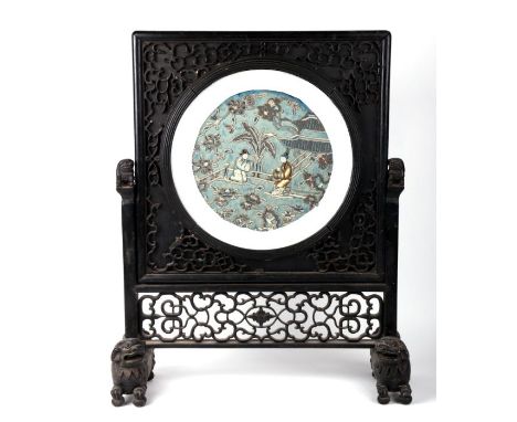 A 19th century Chinese ebonised hardwood table screen on Fo Dog feet with central circular silk embroidered panel depicting f
