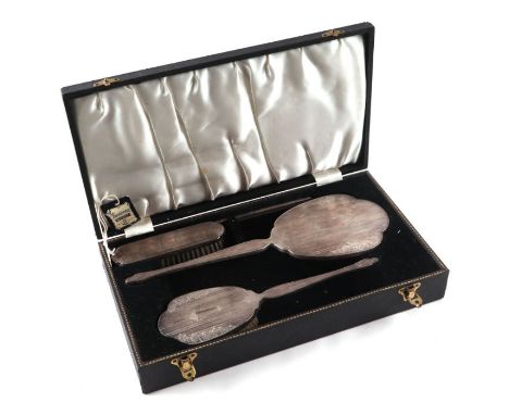 A boxed four-piece silver dressing table set to include hand mirror, clothes brush, hair brush and comb, Birmingham 1962.