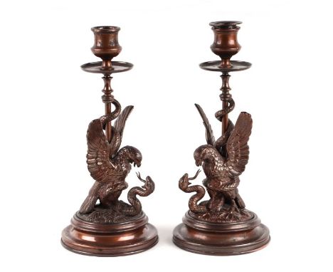 A pair of 19th century bronze candlesticks with eagle and snake columns, 23cms high (2).