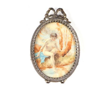 A portrait miniature on celluloid in a bow top frame depicting a naked lady bathing in a river, initialled 'RMK', overall 9.5