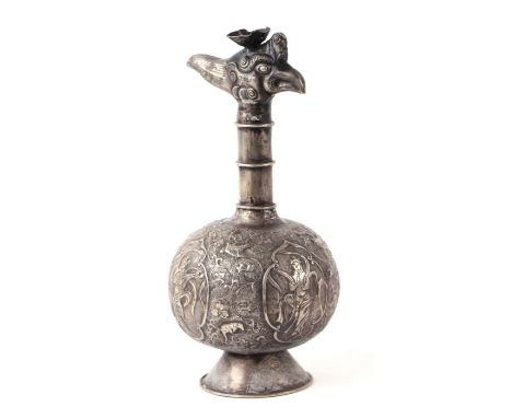 A Chinese silver coloured metal jug decorated in relief with figures within panels and phoenix head terminal, 21cms high.