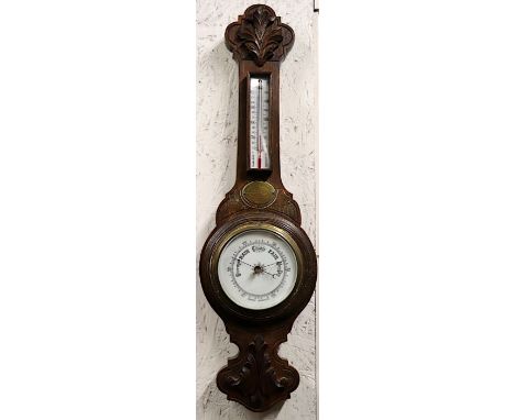 An Edwardian barometer thermometer in a carved oak case, 67cms high.