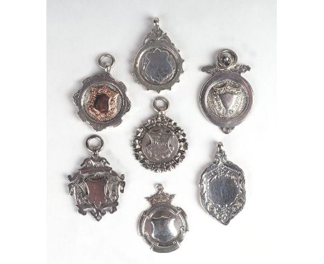 Seven silver pocket watch chain fobs to include a very heave example with gold shield, 61g.