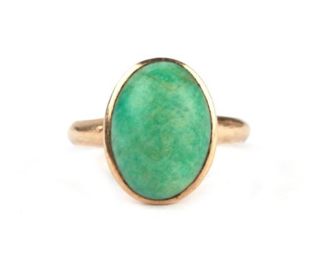 A yellow metal ring set with an oval jade cabochon, approx UK size 'G', 2.4g.