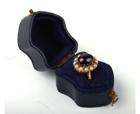 A 9ct gold ring set with a large oval garnet cabochon surrounded by pearls, (one pearl missing), boxed,  Approx UK size O, 3.