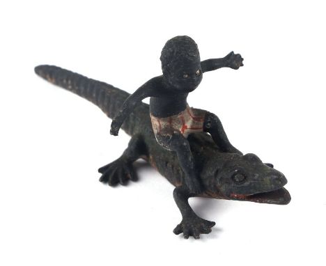 An antique novelty Vienna cold painted bronze miniature depicting a black boy ridding a crocodile, 7.5cms long.