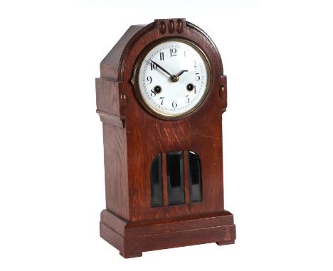 An early 20th century oak cased mantle clock, the white enamel dial with Arabic numerals, 39cms high.