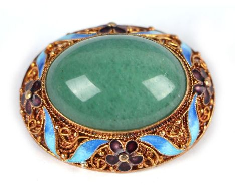 A Chinese silver gilt and enamel oval brooch with central green hardstone cabochon.