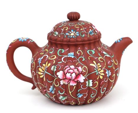 A Chinese Yixing pottery teapot with foliate enamel decoration, four character mark to the underside, 12cms high; together wi