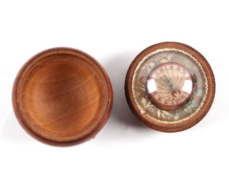 An 18th century French pocket sundial compass with painted paper dial under a glass dome within a treen cover, 5cms diameter.