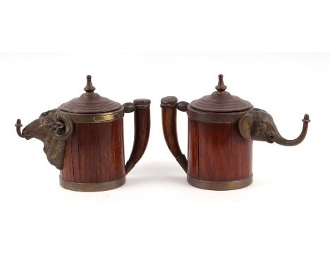 A pair of 19th century Prussian brass mounted oak welcome jugs with elephant and ram masks, incorporating an oil lamp cigar l