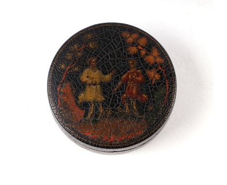 A Russian circular papier-mâché snuff box, the cover decorated with figures within a landscape, 7cms diameter.