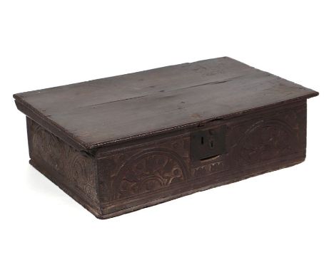 A 17th century oak bible box, the front panel with carved decoration, 68cms wide.