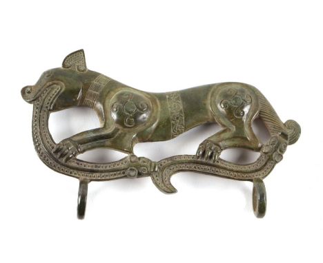 A Celtic type bronzed metal plaque depicting a stylised dog and snake with loops below, 14.5cms wide.