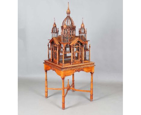 A late 20th century hardwood and wire architectural birdcage, raised on turned legs, height 180cm, width 70cm (some faults).
