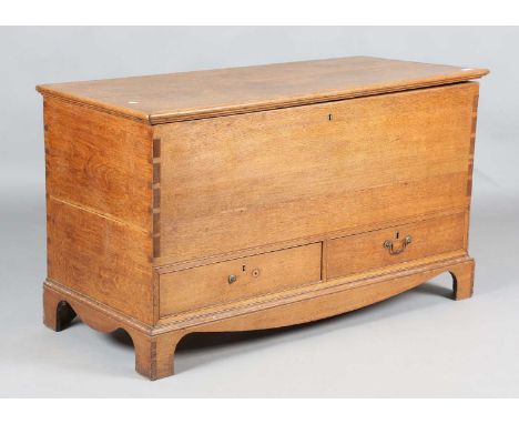An early 20th century George III style oak trunk, the hinged lid above two drawers, height 66cm, width 117cm, depth 52cm.