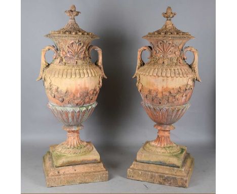 A pair of impressive 20th century terracotta-tinted composition stone garden urns and covers, each lid with a pineapple finia