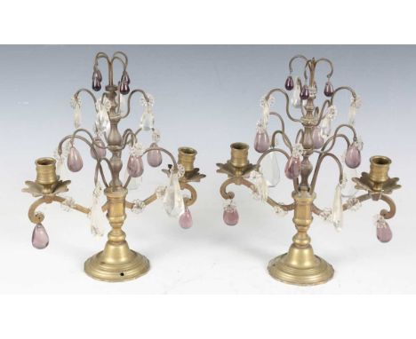 A pair of late 19th century brass two-light candelabra, each with wirework scrolls hung with clear and amethyst glass drops, 
