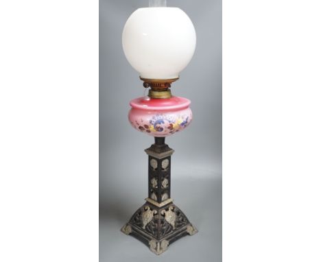 A Victorian cast iron and enamelled glass oil lamp