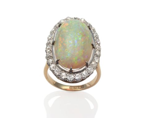 An opal and diamond cluster ring, an oval cabochon opal in white claw settings within a border of old cut diamonds, on a yell