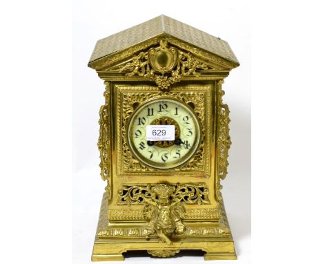 A gilt brass striking mantel clock, circa 1890, architectural pediment, pierced sides and the front with a mask and cherub mo