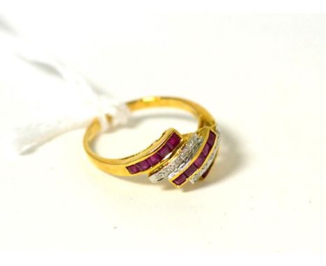 A ruby and diamond ring, three diagonal bands of step cut rubies in yellow channel settings, spaced by bands of pavé set roun