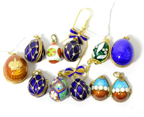 Eight egg charms, enamelled in assorted colours, some set with white paste stones and some hinged to open. And a pair of egg 