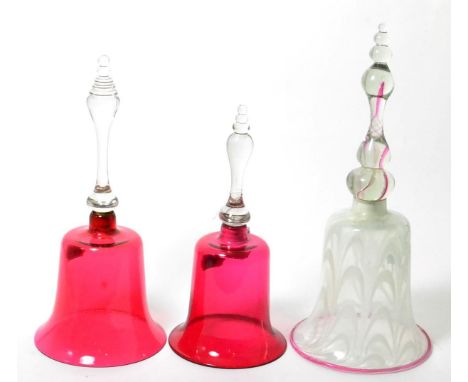 Two ruby glass table bells, tallest 30cm high; and a latticino and glass table bell (3)      
