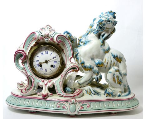 A ceramic striking mantel clock, circa 1900, the pink, blue and gilt decorated case depicting a lion raising its paw, enamel 