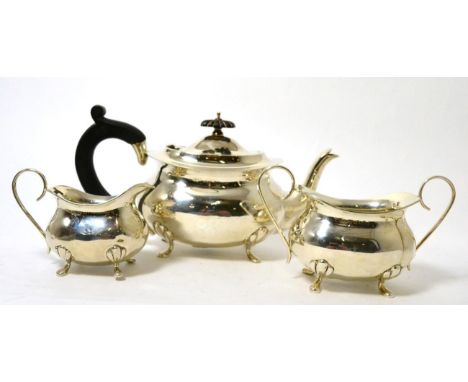 A George V silver three piece tea service, Birmingham 1911, of ovoid form on fluted feet, comprising teapot, milk jug and sug