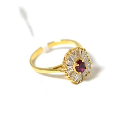 A ruby and diamond cluster ring, an oval cut ruby within a border of tapering baguette cut diamonds in yellow claw settings, 