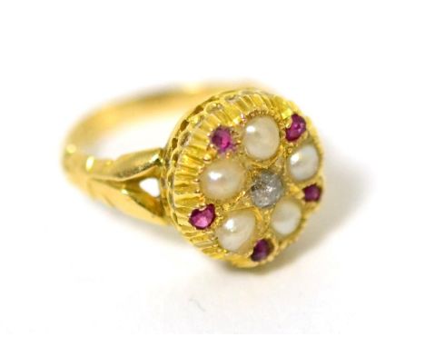 A diamond, ruby and split seed pearl ring, star set with an old cut diamond within a border of split seed pearls and round cu