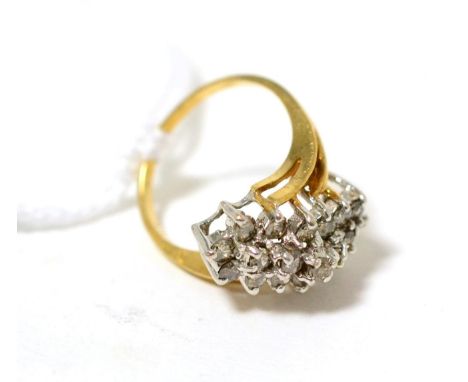 A diamond cluster ring, a three row cluster of round brilliant cut diamonds in white claw settings, to bifurcated shoulders o