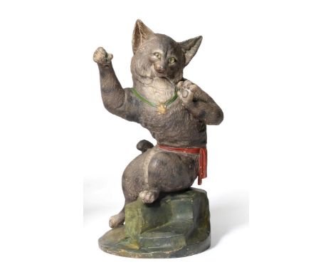 A French cold painted terracotta figure of a cat, circa 1900, sitting upright, its forepaws raised, wearing a star medal on g