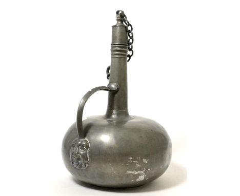 An 18th century French pewter wine flask and stopper, of onion form with loop handle and mask terminal, 30cm high  Provenance