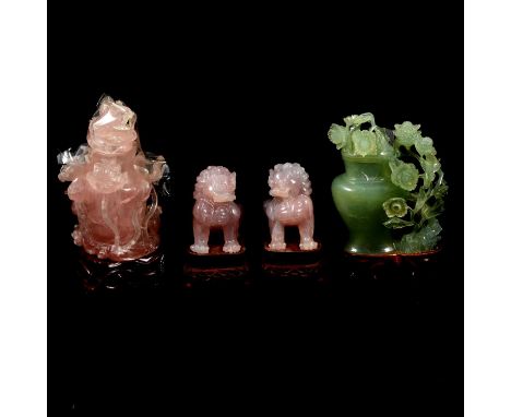 A pair of modern rose quartz temple dogs, 8cm on wooden stands, a Japanese carved rose quartz jar and cover surrounded by by 