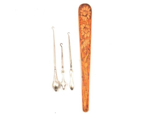 Wooden page turner, penwork decoration, 45cm, and three silver handled button hooks.Qty: 4