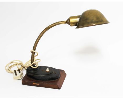 An early 20th century brass angle lamp on stepped oval base and wooden plinth, max height 57cm.  