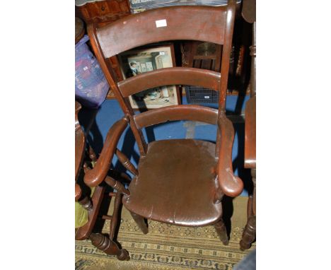An Elm seated kitchen elbow Chair having ladder back and turned legs and stretchers with later varnished finish.