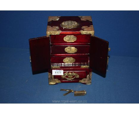 An oriental brass bound Cabinet/jewellery Box with doors with jade like panels and enclosed are three drawers above a double 