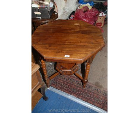 An octagonal mixed woods Edwardian occasional Table standing on turned legs and with galleried lower shelf, 29 1/2'' diameter