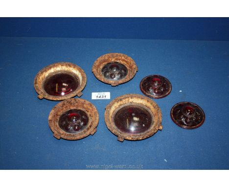 A quantity of red vintage car light reflectors.