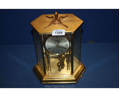 A German made Kundo brass finished and glass 6 sided cased 400 day running mantle clock. A plaque to the back engraved "April