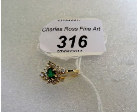 An emerald and diamond cluster ring, the oval cut emerald claw mounted within a border of single cut diamonds, single stone d