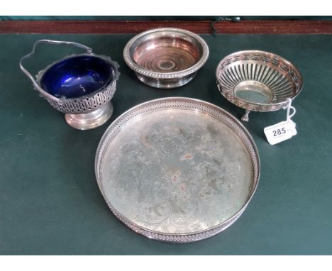 Four items of silver plate, comprising: a galleried circular tray, a wine coaster, pedestal basket with blue glass liner and 