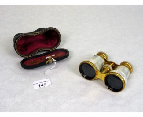 A pair of early 20th century brass opera glasses by Negretti & Zambra, having faceted mother of pearl barrels, in original br