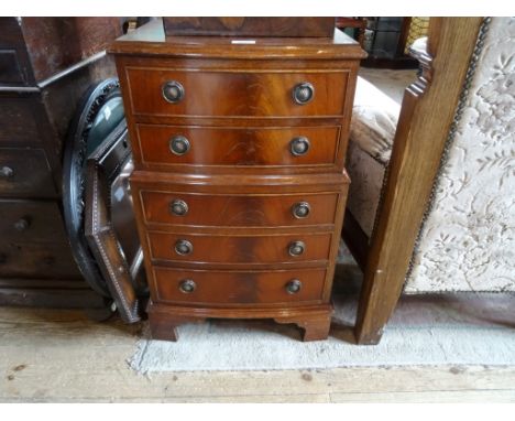 A reproduction bow fronted five drawer narrow chest, (43cm wide).